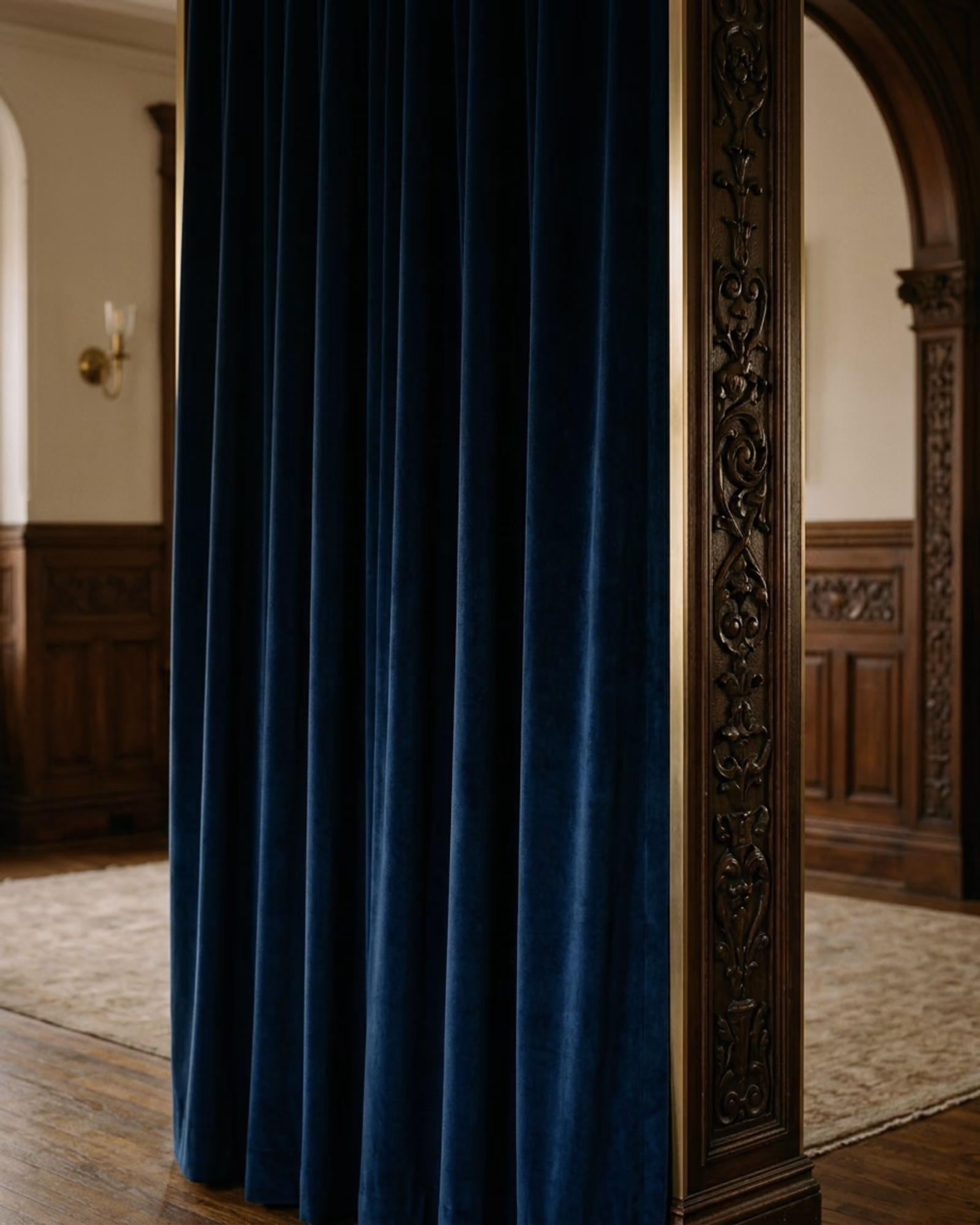 Tenture de velours bleu nuit contre une boiserie sculptée